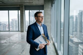 Expert immobilier évaluant un actif professionnel dans un espace de bureaux vide avec architecture béton apparente